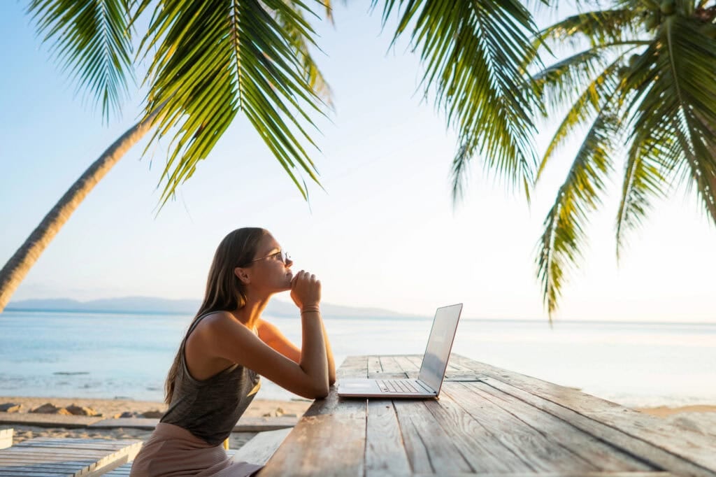 woman thinking and on her laptop for article How to choose a business idea to start
